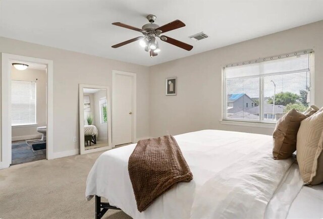 1609 Palcio Real Dr, Houston, TX 77047 - bedroom with multiple windows, light carpet, ensuite bath, and a ceiling fan