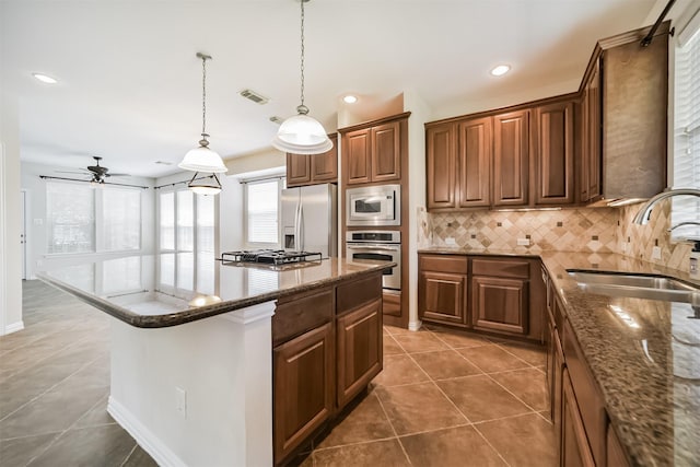 7319 Fair Meadow Ln, Katy, TX 77494 - kitchen featuring appliances with stainless steel finishes, a sink, decorative backsplash, dark stone countertops, and ceiling fan