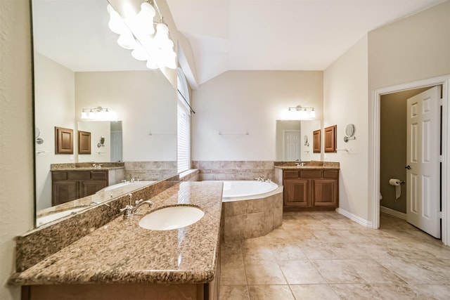 7319 Fair Meadow Ln, Katy, TX 77494 - bathroom with a garden tub, two vanities, tile patterned floors, vaulted ceiling, and a chandelier