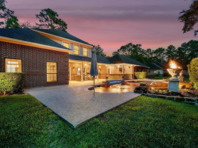 9810 Clubhouse Cir, Magnolia, TX 77354 - back of property featuring a patio, a yard, a pool with connected hot tub, brick siding, and roof with shingles