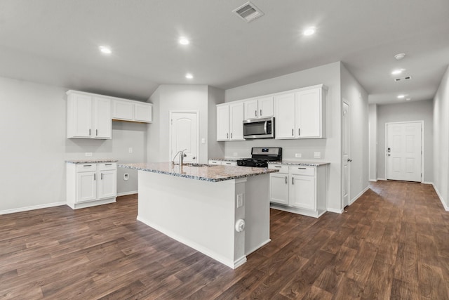 3713 Shady Elk Ct, Conroe, TX 77301 - kitchen with stainless steel microwave, gas range oven, dark wood-style floors, recessed lighting, and light stone countertops