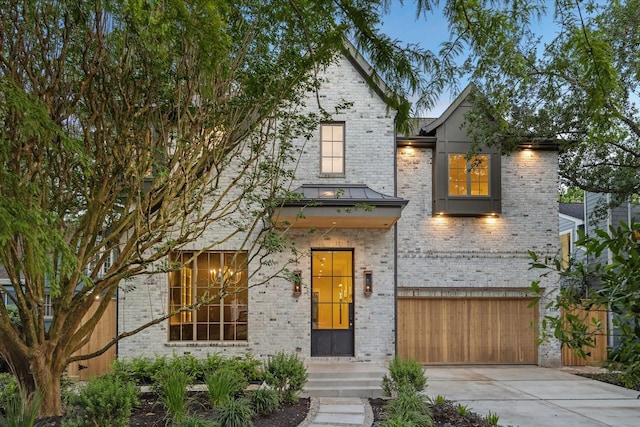 3755 Rice Blvd, Houston, TX 77005 - view of front of property with an attached garage, driveway, brick siding, and a standing seam roof