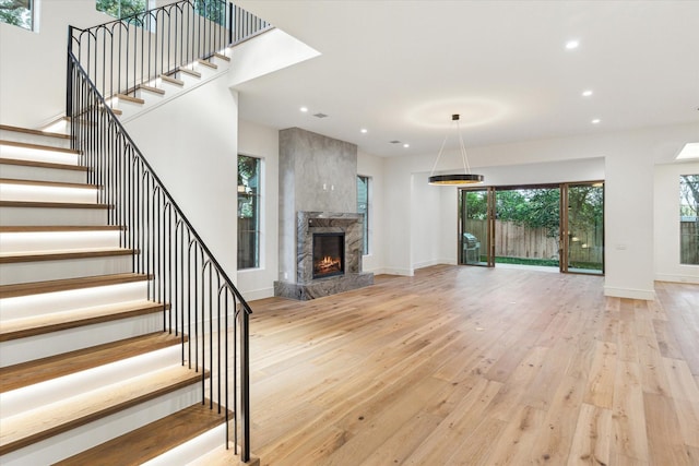 3755 Rice Blvd, Houston, TX 77005 - unfurnished living room with light wood finished floors, recessed lighting, a premium fireplace, stairs, and baseboards