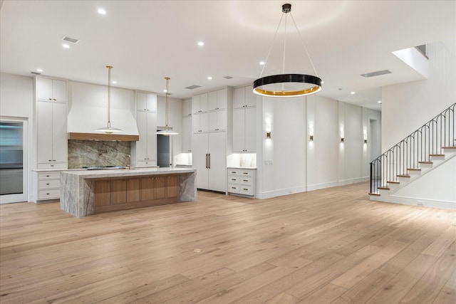 3755 Rice Blvd, Houston, TX 77005 - kitchen with light wood finished floors, light countertops, backsplash, a spacious island, and recessed lighting