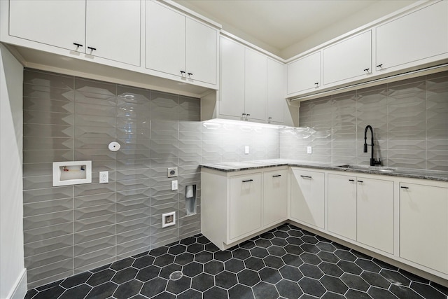 3755 Rice Blvd, Houston, TX 77005 - washroom featuring dark tile patterned flooring, hookup for a washing machine, and cabinet space