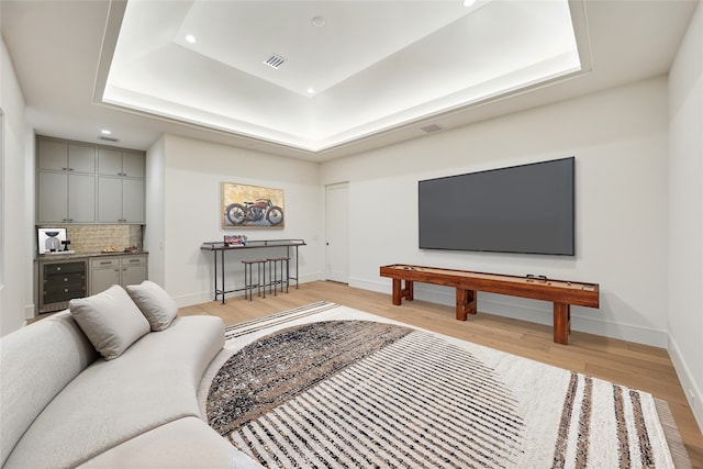 3755 Rice Blvd, Houston, TX 77005 - living area featuring beverage cooler, a tray ceiling, light wood finished floors, recessed lighting, and baseboards