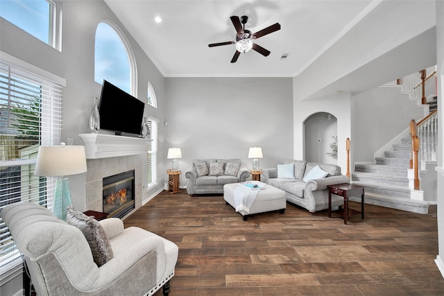 12010 Piney Bend Dr, Tomball, TX 77375 - living room with arched walkways, ceiling fan, stairs, a fireplace, and ornamental molding