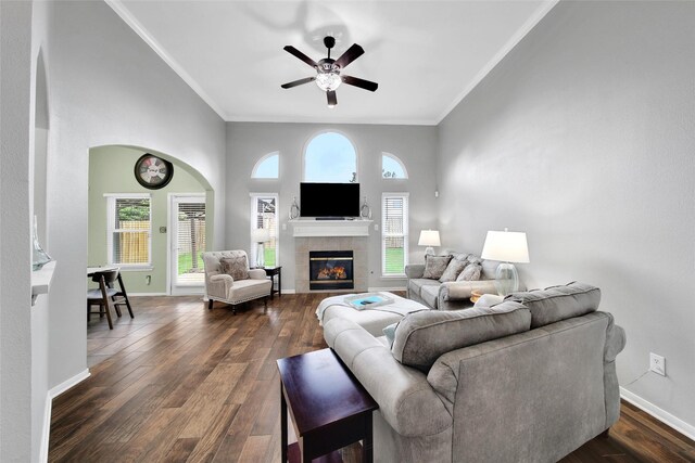 12010 Piney Bend Dr, Tomball, TX 77375 - living room featuring ornamental molding, ceiling fan, a tile fireplace, dark wood-type flooring, and baseboards
