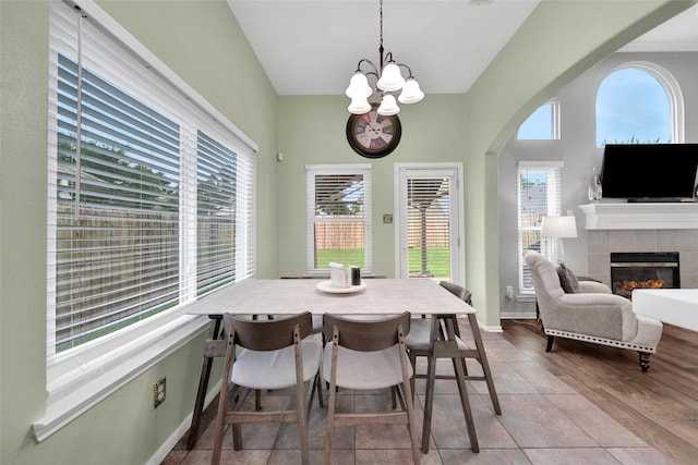 12010 Piney Bend Dr, Tomball, TX 77375 - dining space with a chandelier, a tiled fireplace, baseboards, and tile patterned floors