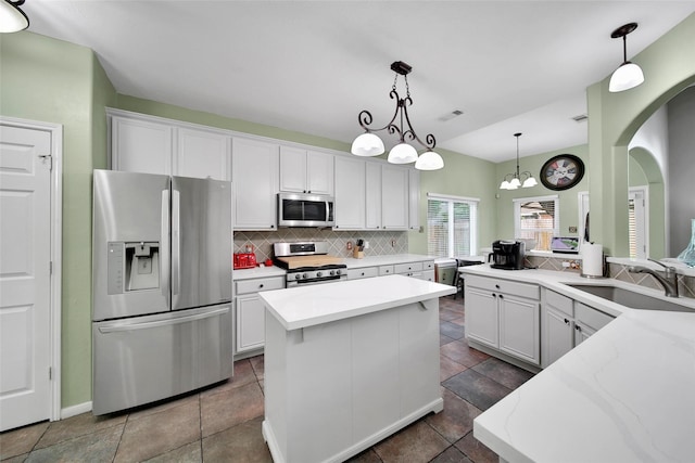 12010 Piney Bend Dr, Tomball, TX 77375 - kitchen featuring stainless steel appliances, a sink, backsplash, white cabinets, and a kitchen island