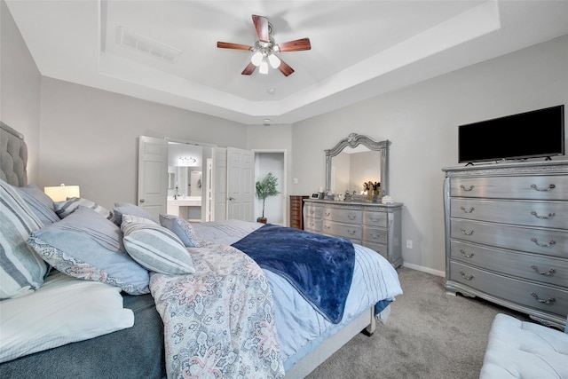 12010 Piney Bend Dr, Tomball, TX 77375 - carpeted bedroom featuring a tray ceiling, ensuite bathroom, baseboards, and ceiling fan