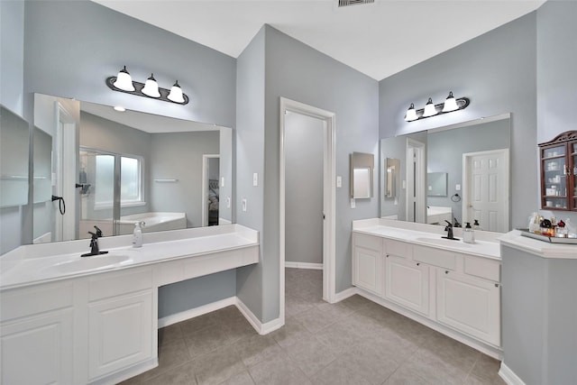 12010 Piney Bend Dr, Tomball, TX 77375 - full bath featuring tile patterned floors, two vanities, and baseboards