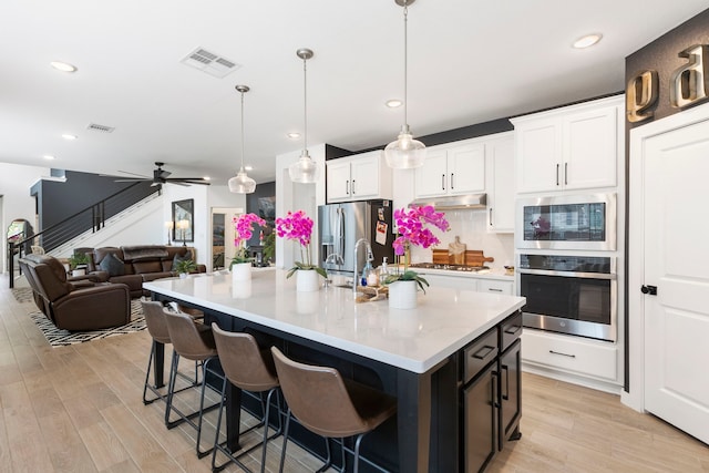 221 Sky Top Dr, Montgomery, TX 77316 - kitchen featuring appliances with stainless steel finishes, light wood-type flooring, white cabinetry, light countertops, and recessed lighting