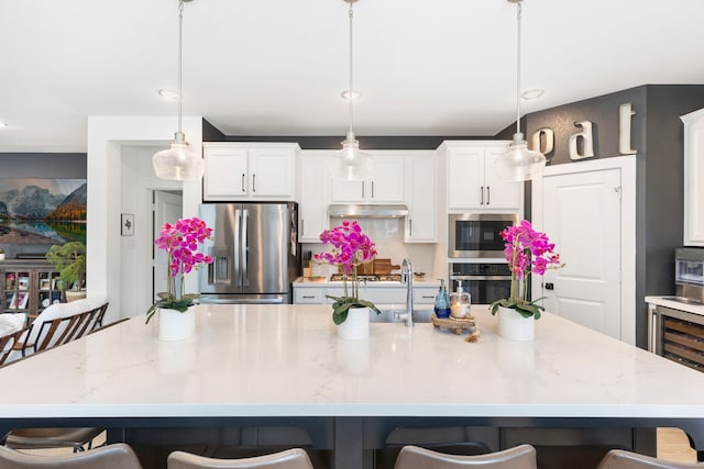 221 Sky Top Dr, Montgomery, TX 77316 - kitchen with stainless steel appliances, a kitchen bar, and white cabinetry