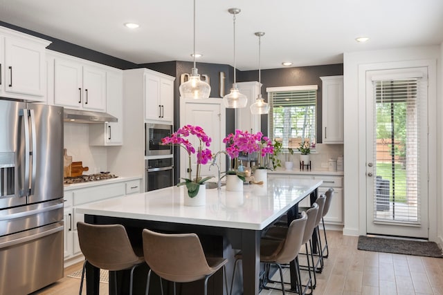 221 Sky Top Dr, Montgomery, TX 77316 - kitchen with stainless steel appliances, a breakfast bar, light countertops, white cabinets, and recessed lighting