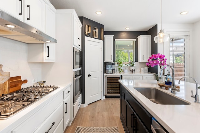 221 Sky Top Dr, Montgomery, TX 77316 - kitchen featuring beverage cooler, under cabinet range hood, a sink, stainless steel appliances, and healthy amount of natural light