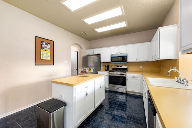 4907 Sienna Heights Ln, Pasadena, TX 77505 - kitchen with stainless steel appliances, a sink, light countertops, and arched walkways