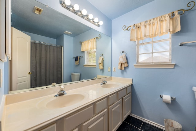 4907 Sienna Heights Ln, Pasadena, TX 77505 - full bathroom featuring toilet, tile patterned floors, double vanity, and plenty of natural light