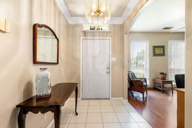 4907 Sienna Heights Ln, Pasadena, TX 77505 - foyer entrance featuring a chandelier, arched walkways, crown molding, light tile patterned floors, and baseboards