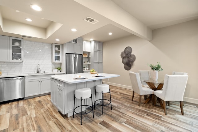 137 Litchfield Ln, Houston, TX 77024 - kitchen with stainless steel appliances, a sink, a breakfast bar, a center island, and tasteful backsplash