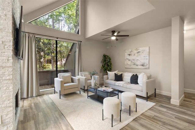 137 Litchfield Ln, Houston, TX 77024 - living room with a fireplace, wood finished floors, a ceiling fan, and baseboards