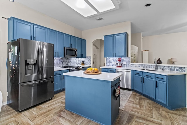 5523 Waverdale Ct, Sugar Land, TX 77479 - kitchen featuring stainless steel appliances, blue cabinets, arched walkways, and a sink