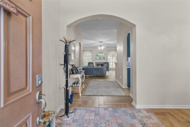5523 Waverdale Ct, Sugar Land, TX 77479 - entryway with a ceiling fan, baseboards, a glass covered fireplace, and arched walkways