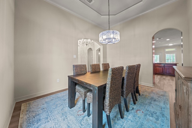 261 Ridge Lake Dr, Montgomery, TX 77316 - dining room featuring arched walkways, light wood finished floors, crown molding, baseboards, and a chandelier