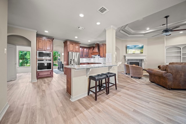 261 Ridge Lake Dr, Montgomery, TX 77316 - kitchen with ornamental molding, stainless steel appliances, a kitchen bar, light stone counters, and a peninsula