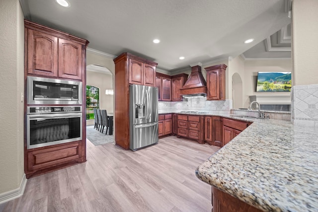261 Ridge Lake Dr, Montgomery, TX 77316 - kitchen with appliances with stainless steel finishes, arched walkways, custom range hood, crown molding, and a sink