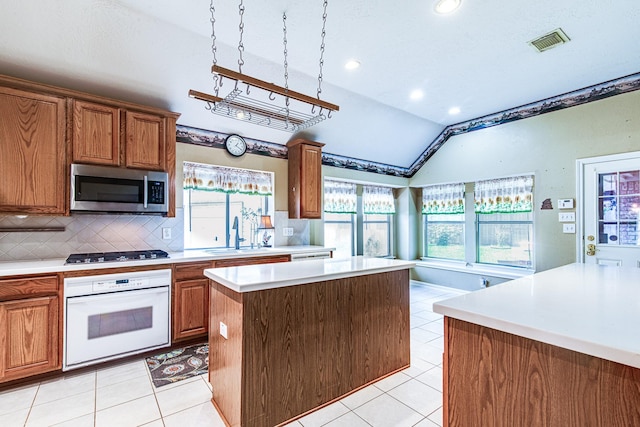 2207 Desert Vine Ct, Sugar Land, TX 77498 - kitchen featuring white oven, stainless steel microwave, a sink, lofted ceiling, and light countertops
