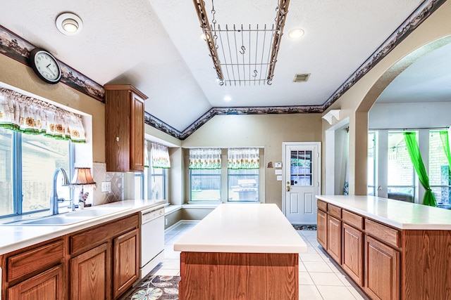 2207 Desert Vine Ct, Sugar Land, TX 77498 - kitchen with dishwasher, a sink, a kitchen island, arched walkways, and light countertops