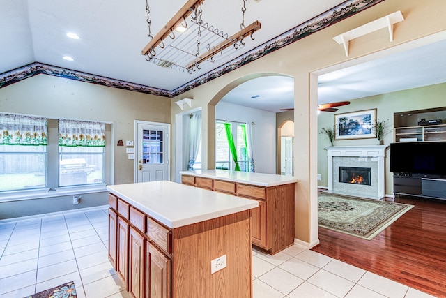 2207 Desert Vine Ct, Sugar Land, TX 77498 - kitchen featuring open floor plan, a fireplace, arched walkways, light countertops, and ceiling fan