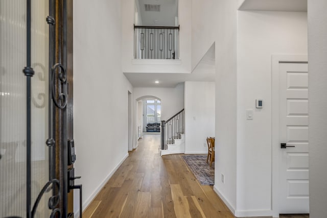 3111 Lantana Trl, Katy, TX 77493 - foyer featuring stairs, arched walkways, wood finished floors, baseboards, and a towering ceiling