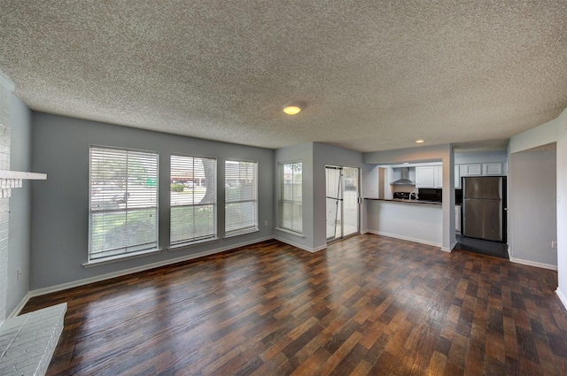 250 El Dorado Blvd Unit 103, Houston, TX 77598 - unfurnished living room featuring dark wood-type flooring, a textured ceiling, baseboards, and a brick fireplace