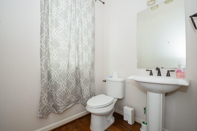 1404 W 26th St Unit C, Houston, TX 77008 - bathroom with wood finished floors, toilet, baseboards, and curtained shower