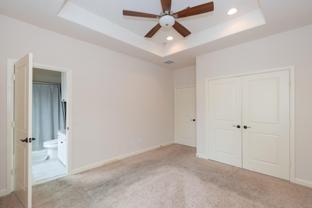 1404 W 26th St Unit C, Houston, TX 77008 - unfurnished bedroom with a raised ceiling, carpet, a closet, baseboards, and ensuite bath
