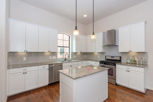 1404 W 26th St Unit C, Houston, TX 77008 - kitchen featuring stainless steel appliances, wall chimney range hood, a sink, a kitchen island, and white cabinetry
