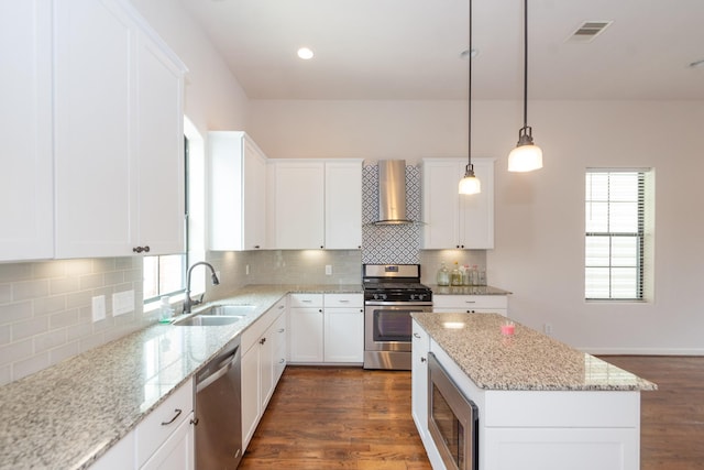 1404 W 26th St Unit C, Houston, TX 77008 - kitchen with stainless steel appliances, wall chimney exhaust hood, a sink, and dark wood-style flooring