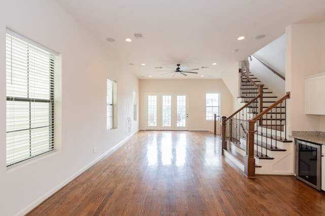 1404 W 26th St Unit C, Houston, TX 77008 - unfurnished living room featuring beverage cooler, wood finished floors, a ceiling fan, stairs, and baseboards