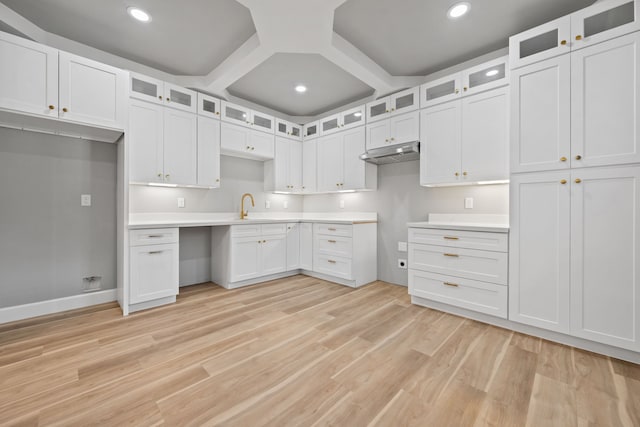 7024 Avenue Ave E, Houston, TX 77011 - kitchen with recessed lighting, light wood-style floors, under cabinet range hood, glass insert cabinets, and white cabinets
