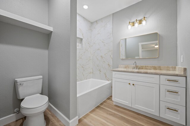 7024 Avenue Ave E, Houston, TX 77011 - bathroom featuring vanity, wood finished floors, toilet, shower / bathtub combination, and baseboards