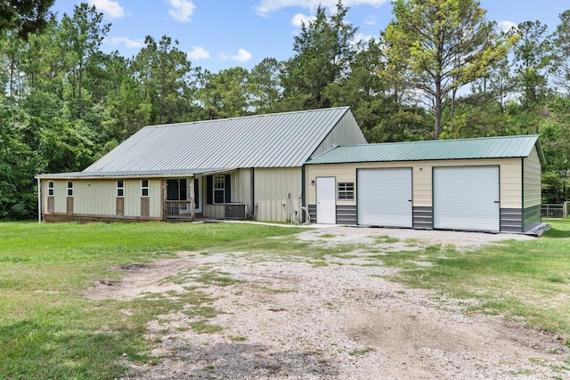 9 Wood Forest Dr, New Waverly, TX 77358 - view of front of home with board and batten siding, a front lawn, metal roof, and a porch
