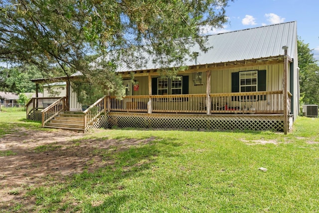 9 Wood Forest Dr, New Waverly, TX 77358 - view of front facade featuring central air condition unit, a porch, a front yard, and metal roof