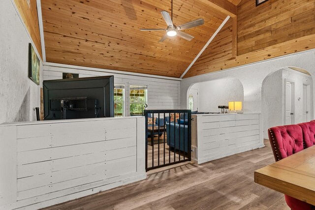 9 Wood Forest Dr, New Waverly, TX 77358 - living area featuring arched walkways, ceiling fan, wood finished floors, wood ceiling with exposed beams, and wood walls