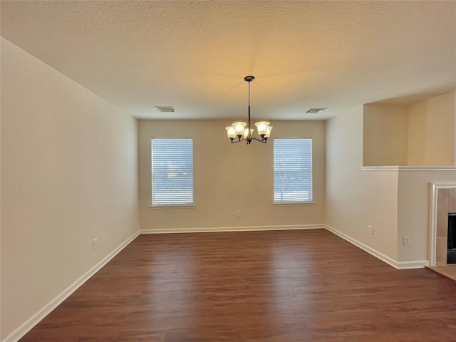 21807 Olympia Springs Ln, Katy, TX 77449 - unfurnished dining area with a chandelier, dark wood finished floors, baseboards, healthy amount of natural light, and a textured ceiling