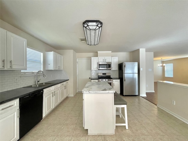 21807 Olympia Springs Ln, Katy, TX 77449 - kitchen featuring stainless steel appliances, a sink, tasteful backsplash, a kitchen island, and light tile patterned floors