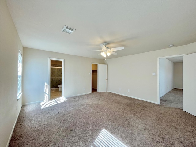 21807 Olympia Springs Ln, Katy, TX 77449 - unfurnished bedroom with carpet, baseboards, ensuite bath, ceiling fan, and a walk in closet