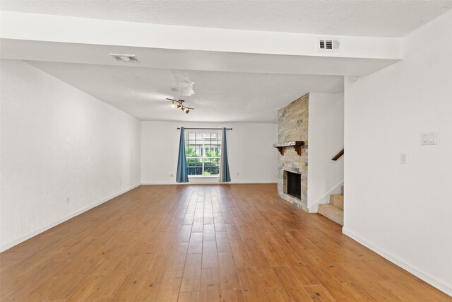 14721 Perthshire Rd, Houston, TX 77079 - unfurnished living room with stairs, light wood-style floors, baseboards, and a fireplace