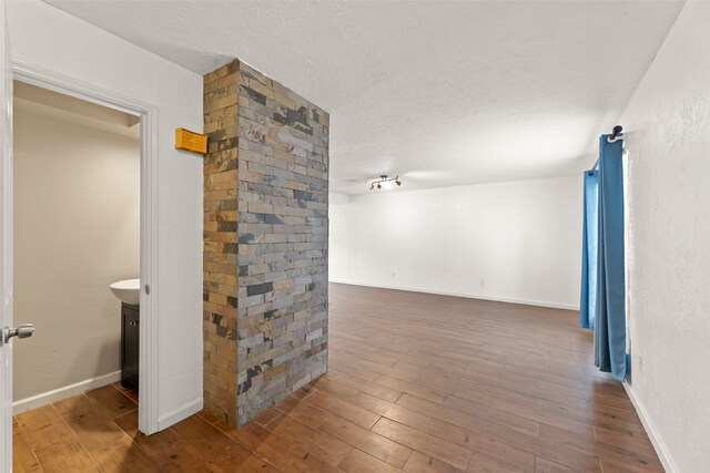 14721 Perthshire Rd, Houston, TX 77079 - corridor featuring wood finished floors, a textured ceiling, and baseboards